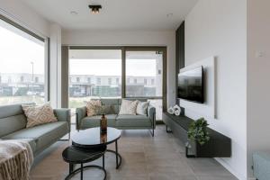 uma sala de estar com um sofá e uma televisão em Brand new pet friendly apartment with parking em Oostende