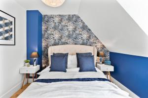 sypialnia z niebieskimi ścianami i łóżkiem z niebieskimi poduszkami w obiekcie The Chaucer - Stylish City Centre Gem - Sleeps 7 w mieście Kent