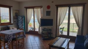 a living room with a television and a table and chairs at Appartamenti Nido d'Aquila in Nago-Torbole