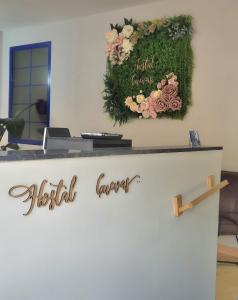 um sinal para um lobby do hotel com flores na parede em Hostal Cuevas em Fuengirola