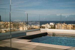 a swimming pool on the roof of a building at The Sliema Suites in Sliema