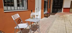 twee stoelen en een tafel met wijnglazen erop bij APARTAMENTOS TURISTICOS LOS ROQUES in Cáceres
