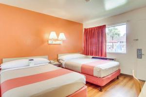 a hotel room with two beds and a window at Motel 6-Jacksonville, FL - Orange Park in Jacksonville