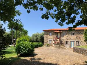 una casa de piedra con un camino que conduce a ella en Eido Oliveira - Casa de Campo - Ponte de Lima, en Anais