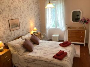a bedroom with a bed with two red towels on it at Sundown in Paillé