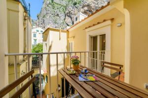 d'un balcon avec une table en bois et une montagne en arrière-plan. dans l'établissement Casa Andreana, à Amalfi