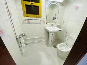 La petite salle de bains est pourvue d'un lavabo et de toilettes. dans l'établissement PRIVATE FAMILY ROOM BY BJ, à Abu Dhabi