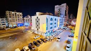 une rue de la ville avec des voitures garées dans un parking dans l'établissement PRIVATE FAMILY ROOM BY BJ, à Abu Dhabi