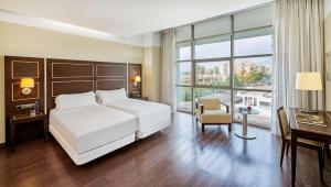 Postel nebo postele na pokoji v ubytování NH Gran Hotel Casino de Extremadura