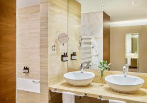 a bathroom with a white sink and a mirror at NH Gran Hotel Casino de Extremadura in Badajoz