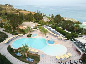 una vista aérea de una piscina con sillas y sombrillas en Labranda Rocca Nettuno Tropea, en Tropea