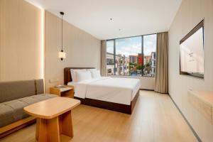 een hotelkamer met een bed en een bank bij Relax Hotel - Shenzhen Bao'an International Airport in Bao'an