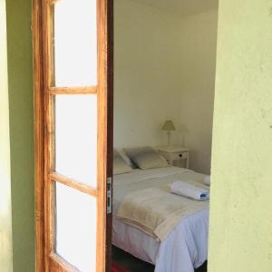 1 dormitorio con 1 cama y puerta con ventana en Hostel de campo La Providencia en Lobos