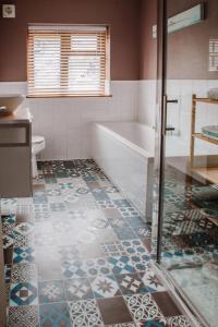 a bathroom with a tub and a tile floor at Our Place In Portland Holiday Home with Sea View in Portland