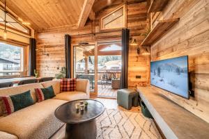 sala de estar con sofá y TV grande en Apartment Pamir Les Gets - by EMERALD STAY, en Les Gets