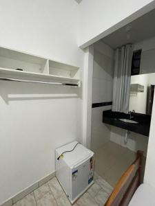a small kitchen with a sink and a refrigerator at Hotel E Flats LISBOA in Presidente Médici