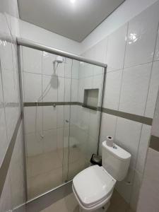a white bathroom with a shower and a toilet at Hotel E Flats LISBOA in Presidente Médici