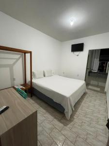 Schlafzimmer mit einem weißen Bett und einem Flachbild-TV in der Unterkunft Hotel E Flats LISBOA in Presidente Médici