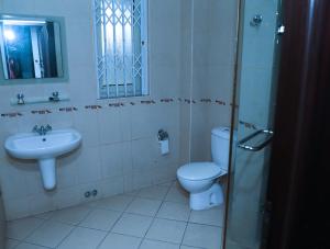 a bathroom with a toilet and a sink at Monarch Hotel in Accra