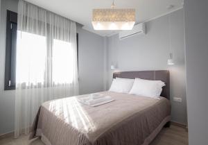 - une chambre avec un lit et 2 serviettes dans l'établissement Sagman Suite by RentalsPro Services - Nea Moudania Halkidiki, à Nea Moudania