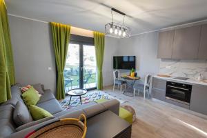 Il comprend un salon avec un canapé et une cuisine. dans l'établissement Sagman Suite by RentalsPro Services - Nea Moudania Halkidiki, à Nea Moudania