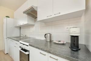 a white kitchen with a coffee maker on a counter at Wilczak Spacious Apartment with FREE GARAGE Poznań by Noclegi Renters in Poznań