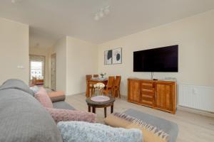 a living room with a couch and a flat screen tv at Wilczak Spacious Apartment with FREE GARAGE Poznań by Noclegi Renters in Poznań