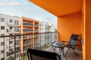 a balcony with two chairs and a table on a balcony at Wilczak Spacious Apartment with FREE GARAGE Poznań by Noclegi Renters in Poznań