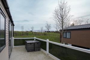 a balcony with a trash can and a fence at ELVIS, King Of The Caravans, Luxury 6 berth in Port Seton