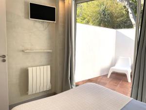 Schlafzimmer mit einem Bett und einem Fenster mit einem TV in der Unterkunft TUSQUETS - Apartamento con vistas al mar in Cadaqués