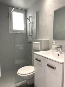 y baño con aseo, lavabo y ducha. en TUSQUETS - Apartamento con vistas al mar, en Cadaqués