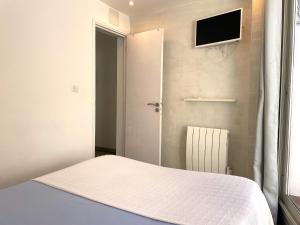 1 dormitorio con 1 cama y TV en la pared en TUSQUETS - Apartamento con vistas al mar, en Cadaqués