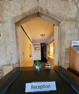 um quarto com uma mesa com uma placa que lê recepção em Schoolhouse Restaurant and Hotel em Swindon