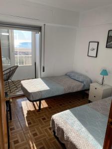 1 dormitorio con 2 camas y ventana con vistas en Primera línea de playa, en Valencia