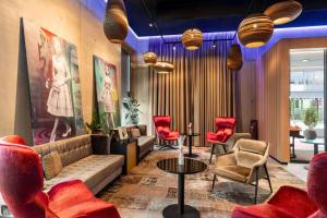 vestíbulo con sofá y sillas rojas en Amedia Lustenau, Trademark Collection by Wyndham, en Lustenau