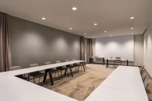 une salle de conférence avec des tables et des chaises blanches dans l'établissement Amedia Lustenau, Trademark Collection by Wyndham, à Lustenau