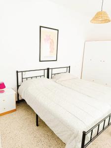 2 camas en un dormitorio con una pared blanca en EL CARPIO CENTRO - Córdoba - WiFi, en El Carpio