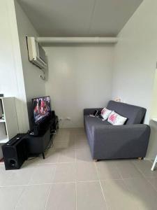 a living room with a couch and a tv at Near Mactan Airport and Indiana Aerospace University, Lapu Lapu City in Pajak