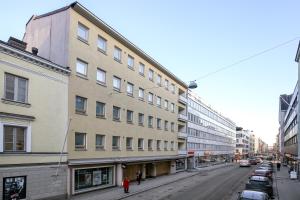 a building on a city street with parked cars at Kotimaailma Apartments Kamppi - 1BR with a key code in Helsinki