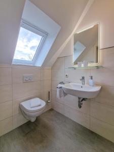 uma casa de banho com um WC, um lavatório e uma janela em Gästehaus Funk em Greetsiel