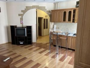 eine Küche mit einem Tisch und einem TV in einem Zimmer in der Unterkunft Апартаменти 3-кімнатні, м. Майдан Незалежності in Kiew
