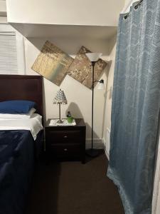 - une chambre avec un lit et une lampe sur une table de chevet dans l'établissement Victorian Palace 3, à East Orange