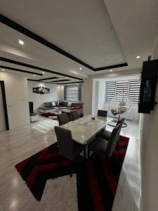 a dining room with a table and chairs and a living room at Apartman Kumalic in Sanski most +11 photos