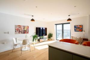 a kitchen and living room with a table and chairs at Beautiful & Contemporary Watford Retreat in Watford