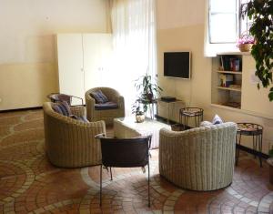 un soggiorno con sedie in vimini e TV di Hotel Nettuno a Milano