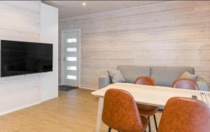 een woonkamer met een tafel en stoelen en een bank bij Villa Lusma in Inari