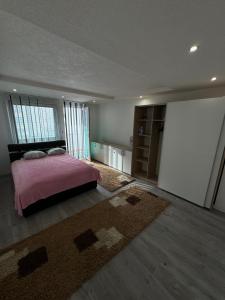 a bedroom with a pink bed and a rug at Apartman Kumalic in Sanski most