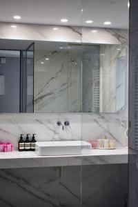 La salle de bains est pourvue d'un lavabo et d'un miroir. dans l'établissement Zeus and Hera Studio, à Athènes