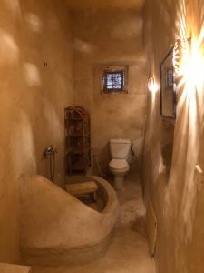 a bathroom with a tub and a toilet at Dar Kenza in Djerba