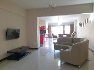 a living room with a couch and a tv at Heaven Heights - Fully Furnished Air Con Apartment in Rose Hill
